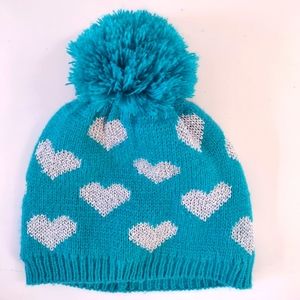 Girls blue knit winter hat with pom pom top and silver hearts